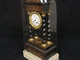 a small clock under a glass dome on a black background