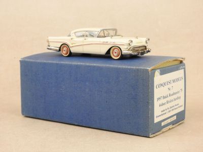 une petite voiture blanche posée sur une boîte bleue