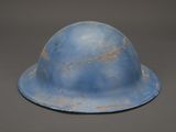 an old blue helmet on a gray surface with a gray background