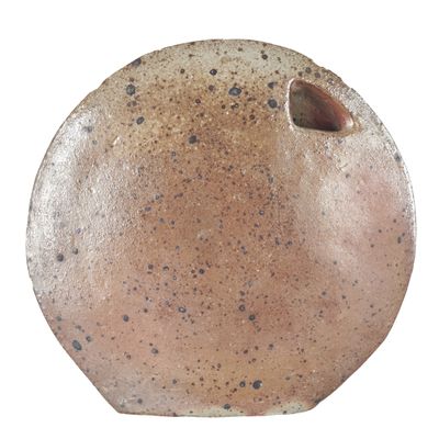 un vase brun posé sur une surface blanche