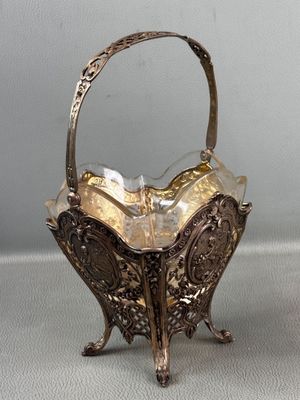 an antique silver plated basket with a handle and handles