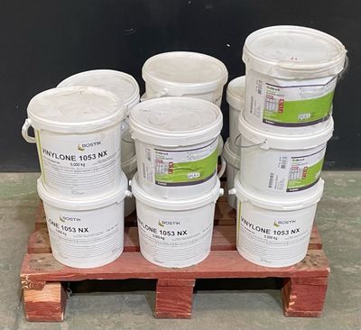 plusieurs seaux de peinture posés sur une palette, sur fond noir