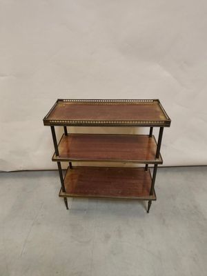 une étagère en bois à trois niveaux avec des finitions en laiton