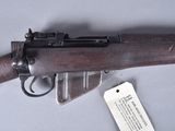 an old gun with a tag on it sitting on a table