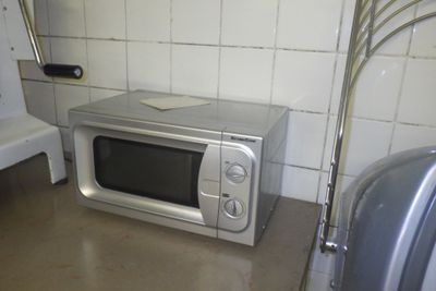 un micro-ondes posé par terre à côté d'une baignoire