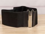 un gros plan d'une ceinture en cuir noir ornée de deux boucles métalliques