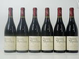 six bouteilles de vin sont alignées sur une table