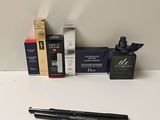 un flacon de liquide, un stylo et une boîte de mascara posés sur une table