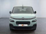 the front of a light blue citrole parked in a white room