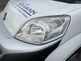 a close up of a white van parked on the side of the road