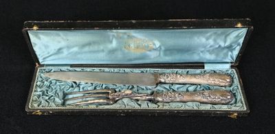 un couteau en argent et une paire de ciseaux dans un étui