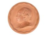 an image of a bronze medallion with a man ' s profile