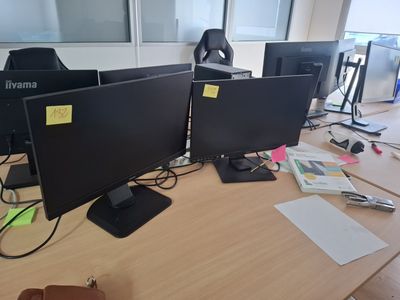 three computer monitors sitting on a desk next to each other