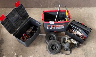 une boîte à outils contenant des outils, posée sur le sol