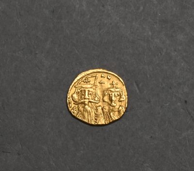a close up of a gold coin on a black surface