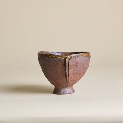 une image représentant un petit bol marron posé sur une table