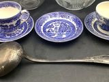 a lot of blue and white dishes and spoons on the table