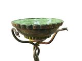un bol vert orné d'un serpent, posé sur un socle
