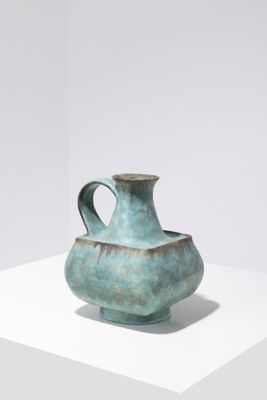 a blue vase sitting on a white surface