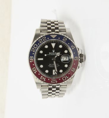 une montre Rolex avec une lunette rouge, blanche et bleue