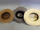 three hats are lined up in a row on a white surface