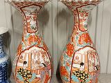 two vases that are sitting on a shelf next to each other