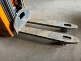 a fork lifter sitting on the floor in a warehouse