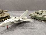 trois chars miniatures et un avion de chasse posés sur une table