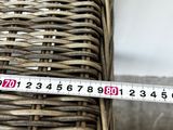 a measuring tape on a wicker chair that is sitting on the floor