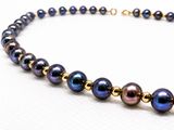 a close up of a necklace on a white surface