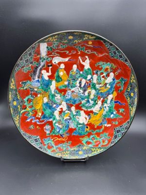 an image of a red and green plate with figures on it