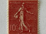 an old stamp with the image of a woman walking on a street