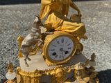 une statue de femme assise au sommet d'une horloge