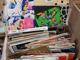 a cardboard box full of records on the floor