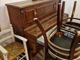 une table avec des chaises et un piano dans une pièce