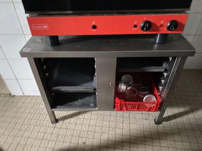 un four de cuisinière rouge posé sur une table en métal
