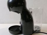 a black cat shaped coffee maker with a glass on the table