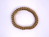a close up of a gold bracelet on a white background