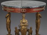 une image représentant une table avec un plateau en marbre sur lequel sont posées des statues