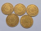 four gold sovereigns, one of which has a crown on it