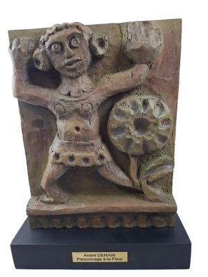 sculpture représentant un homme tenant un rocher, posée sur un socle noir