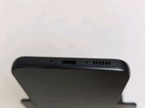the back of a black cell phone sitting on top of a table