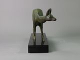 statue of an antelope on a black base against a white background