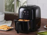 une friteuse à air chaud noire posée sur un plan de travail