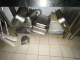 a pile of metal pans sitting on top of a tiled floor