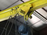 a yellow crane hanging from the ceiling of a building