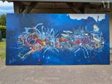 painting of a blue and red abstract painting in front of a building