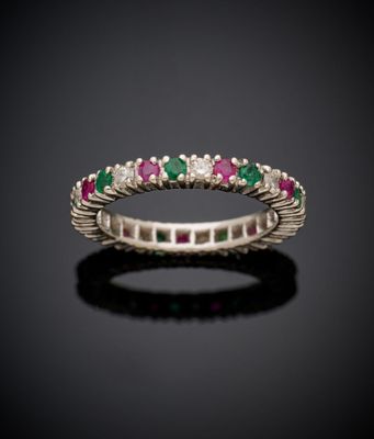un gros plan d'une bague sertie d'un diamant et d'une émeraude sur une surface noire