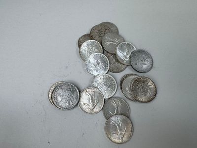 une pile de pièces d'argent posée sur une surface blanche