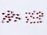 a group of red garnets on a white surface